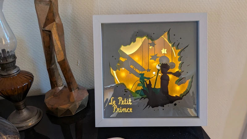 Lightbox Le Petit Prince posée sur meuble en décoration intérieure, cadre blanc, lumière LED chaude