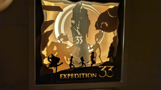 Lightbox artisanale en papier découpé inspirée du jeu Clair Obscur Expedition 33, vue de face éclairée.