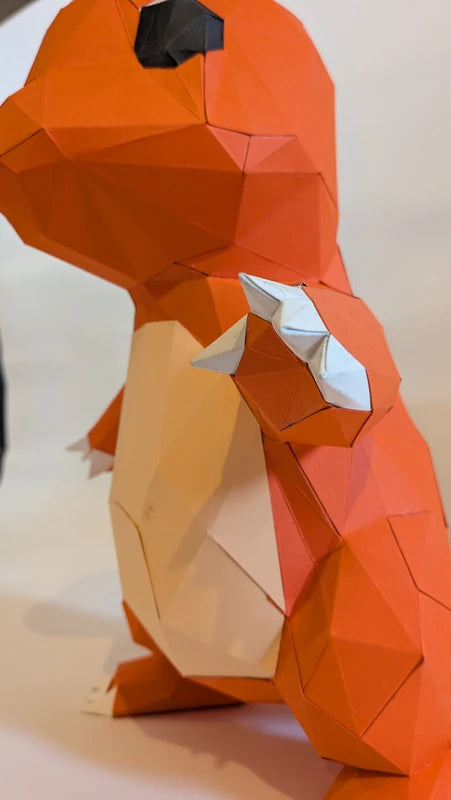 Gros plan sur les pattes et les griffes de Salamèche en papier 3D, kit DIY haute finition.