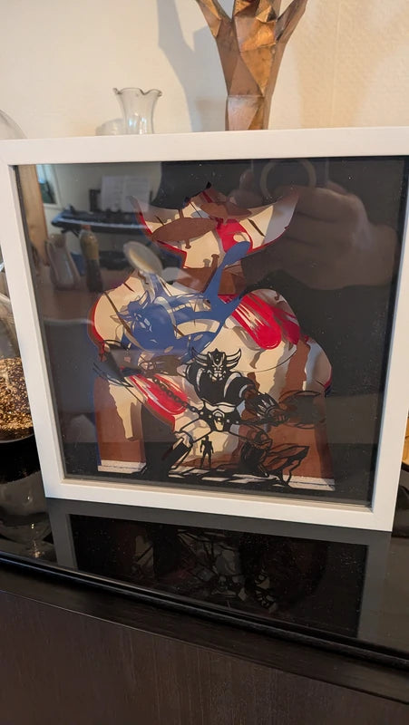 Gros plan sur les couches de papier découpées au laser représentant le robot Goldorak.