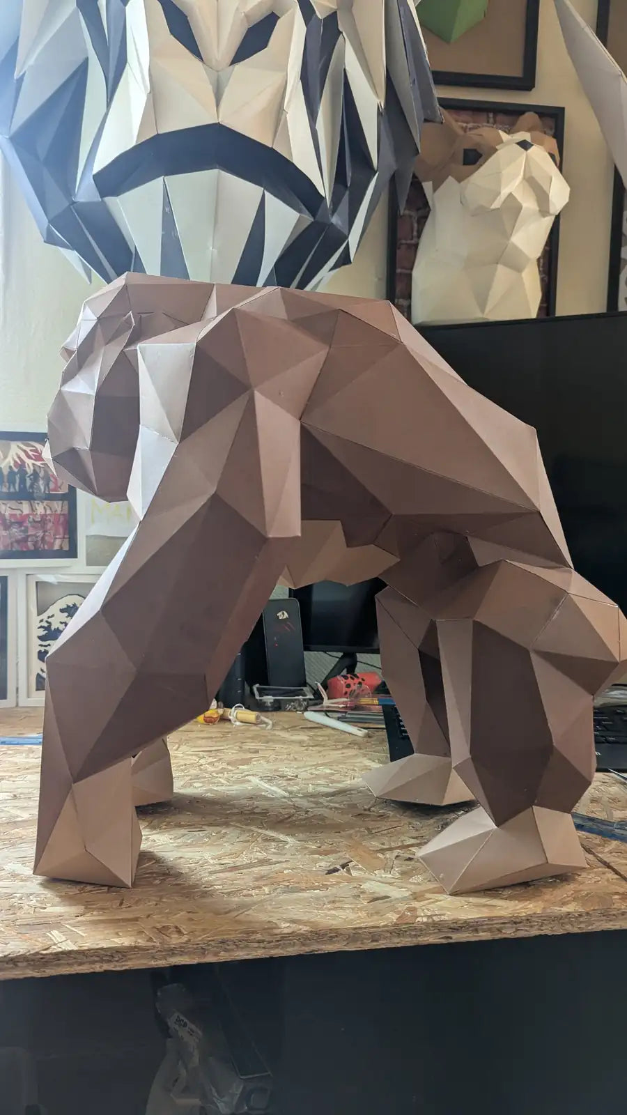 Gorille XL en papercraft marron exposé en atelier, éclairé par la lumière naturelle venant de la fenêtre