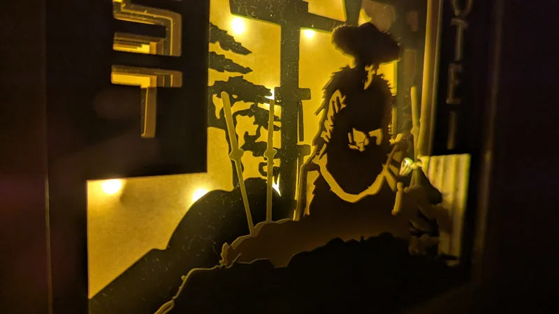 Détail du samouraï éclairé dans la lightbox Ghost of Yotei, style shadowbox en papier découpé