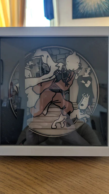 Lightbox Tintin en papier découpé vue éteinte, silhouettes de Tintin, Milou, Haddock, Castafiore et Dupond.