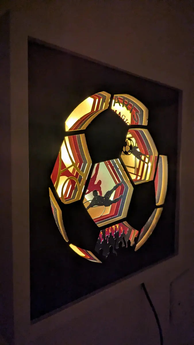 cadre lumineux ballon de foot découpé en papier avec ambiance stade