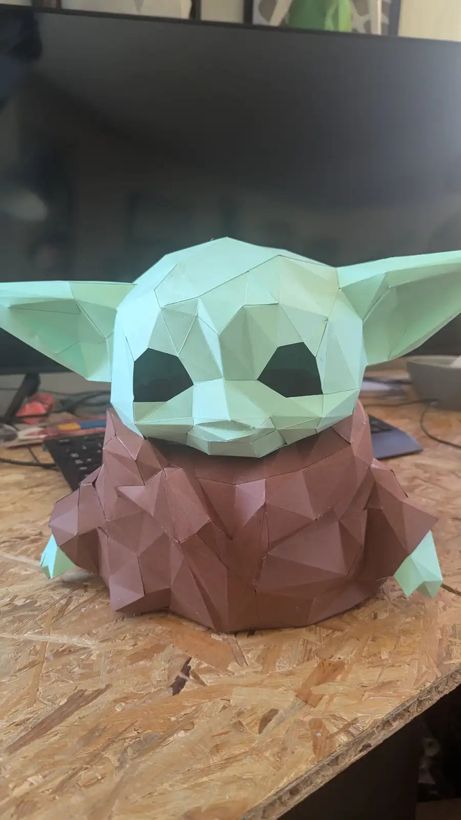 Figurine en papercraft low poly de Grogu (Baby Yoda) vue de face, avec sa tête verte et sa tunique marron.