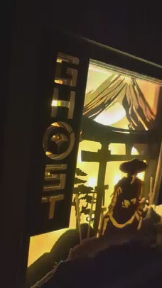 Zoom sur le samouraï éclairé dans la lightbox Ghost of Yotei, découpes précises en papier