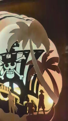 Zoom vidéo sur les silhouettes lumineuses de Luffy et Zoro dans la lightbox One Piece – détails du papier et profondeur des couches