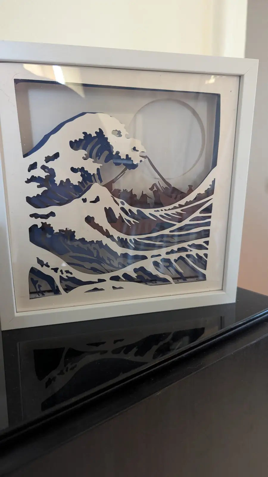 Lightbox artisanale en papier représentant La Grande Vague de Kanagawa, découpe multilayer dans un cadre blanc